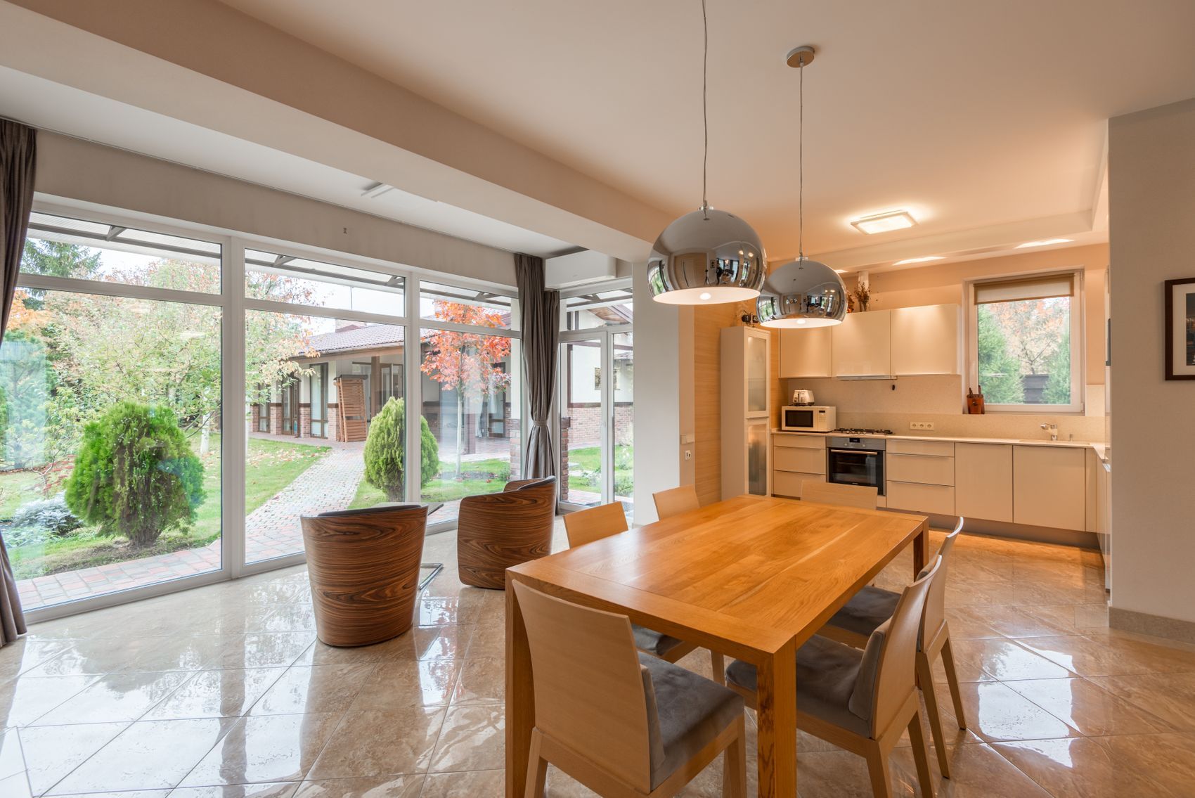 Inside a garden room, dining table against a wall of glass
