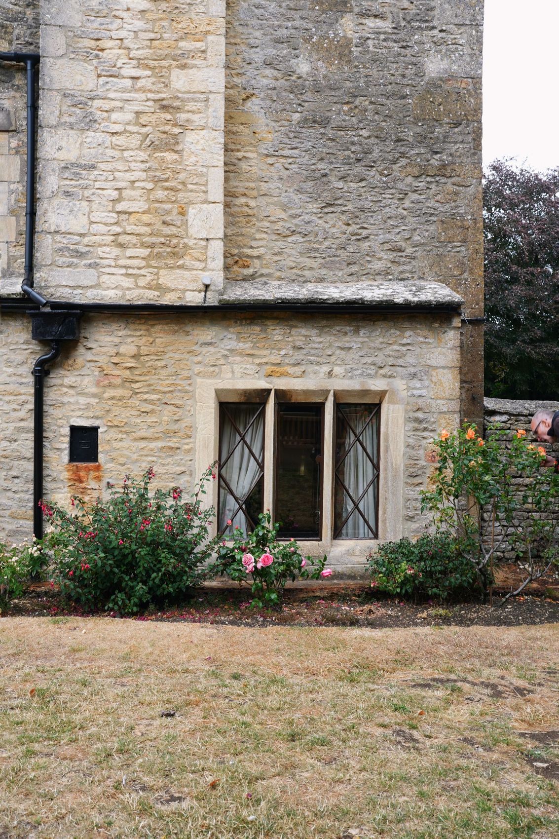 A mullioned window in a honey-coloured Cotswold stone wall